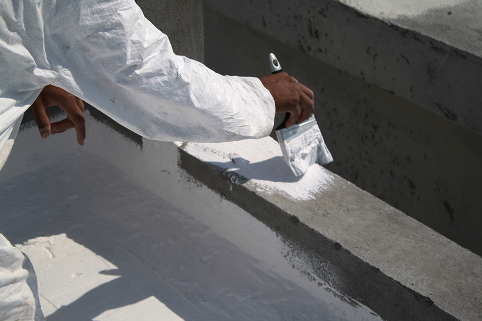 Man Brushing Elastomeric Roof coating on roof