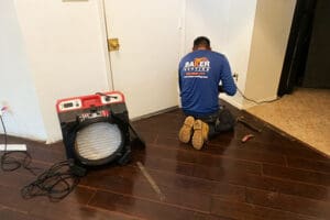 Air scrubber in water damaged room with baker roofing & construction worker