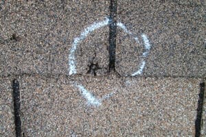 Hail damaged shingles with chalk circle